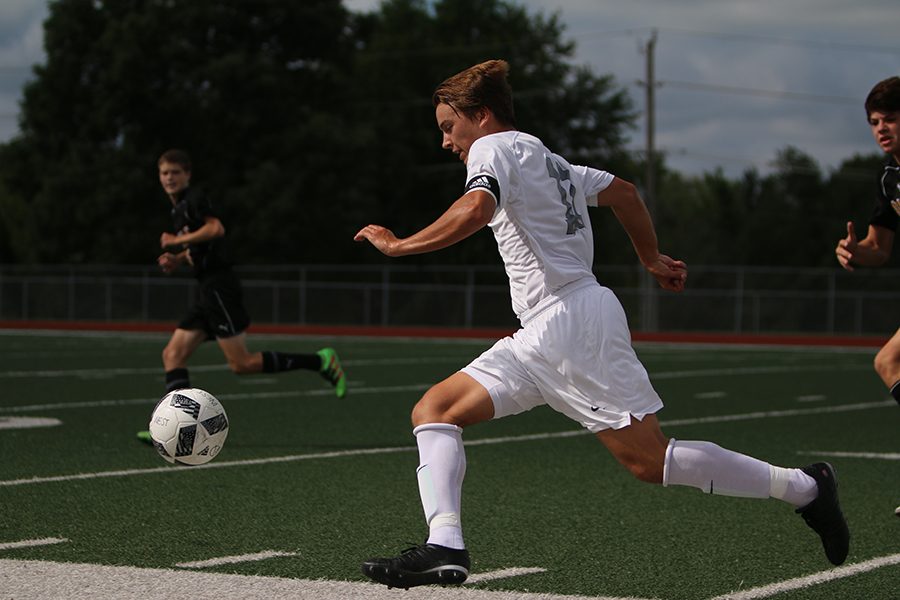 Making his way down the field, junior Jack Galkowski prepares to shoot the ball into the goal. The boys played in the Northwest tournament against Oakville on Aug. 20 with an ending score of 0-3.