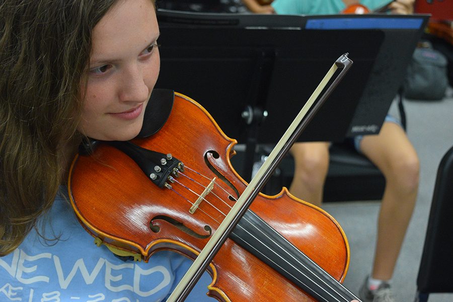 Junior Aimee Laws practices music for the cook-off during her symphonic orchestra class. 
