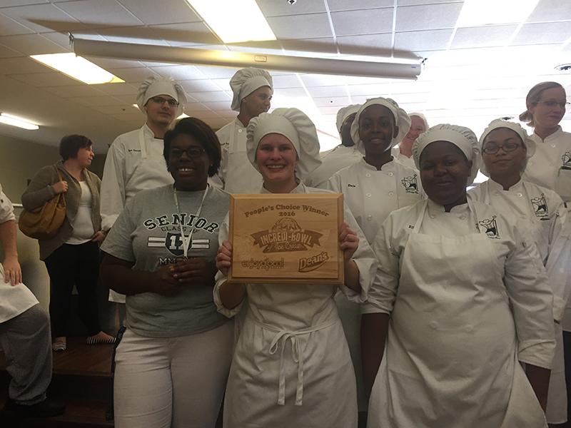 Magee holds her plaque that she won as she poses with her fellow participants.
