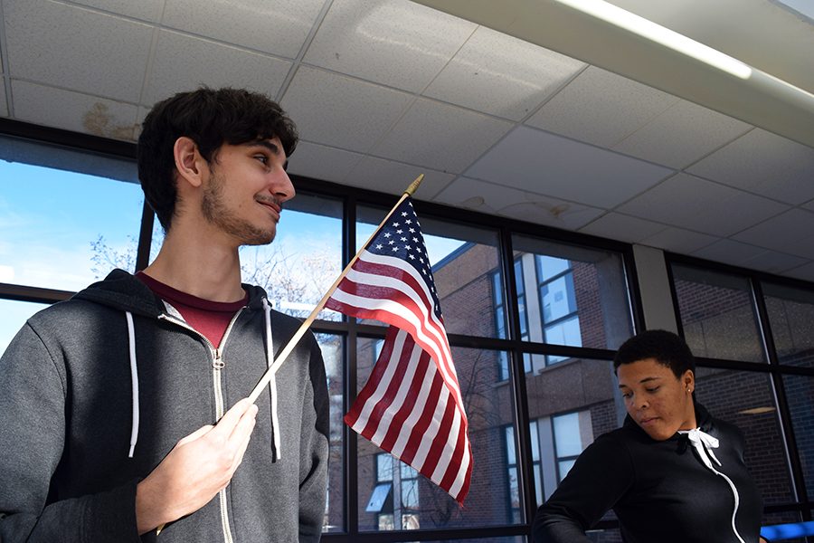 Juniors Jason Zimbelmann and Alyssa Foy stand before one of the American flags found in many classrooms. Zimbelmann stands during the Pledge, but not Foy.