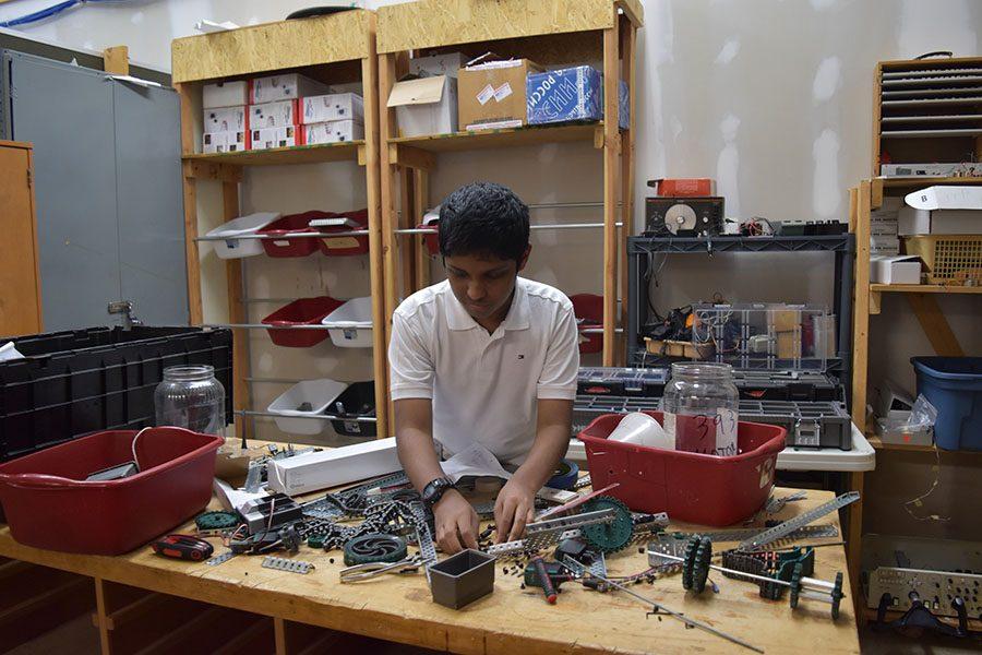 Reaching for a gear, freshman Bhargav Addagarla builds a robot.