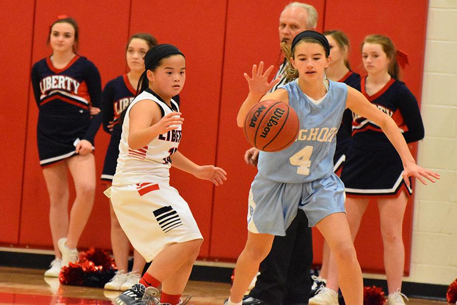 Freshmen Emily Lofgren runs to maintain possession of the basketball against Wentzville Liberty High School on Dec. 15.