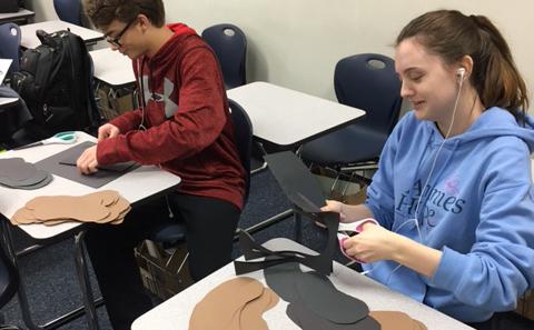 Cutting out brown and black cards, sophomores Rebecca Gibson and Patrick Griffard make liver grams.