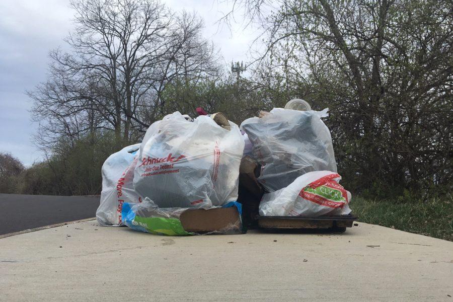 Bags of trash pile up as the road connecting the middle and high school is cleared of litter.