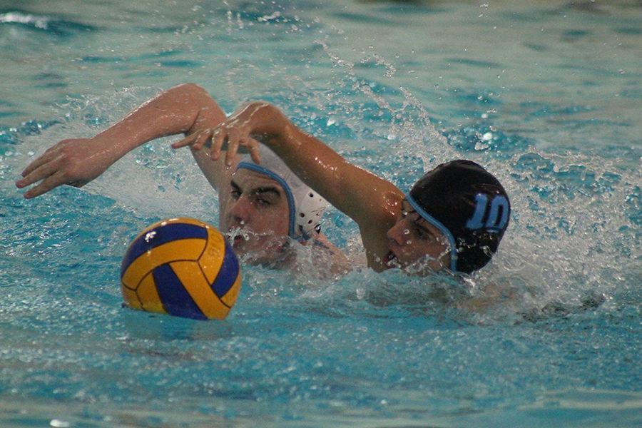 Sophomore Paris Wilken and freshman Ryan Mendonsa swim for the ball as part of their preparation during water polo practice.