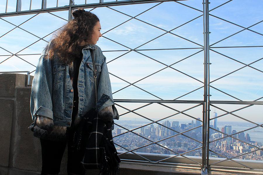 Leigh Ann poses in her Levis jean jacket and sweater on top of the Empire State building.
