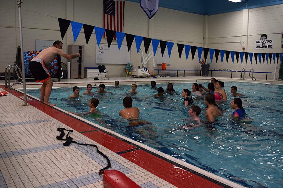 Teacher+Tim+Corteville+instructs+his+primarily+freshman+P.E.+class+from+the+side+of+the+pool+as+a+part+of+the+swim+unit.