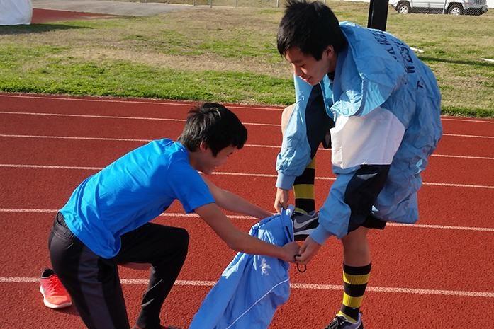 Freshmen Daniel Yu and Jon Ma participate in a warmup relay on the third day of track practice.