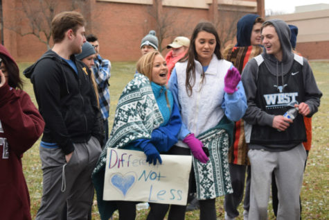 Surrounded by other supporters, junior Vicky Marshall holds a sign showing support for her brother.