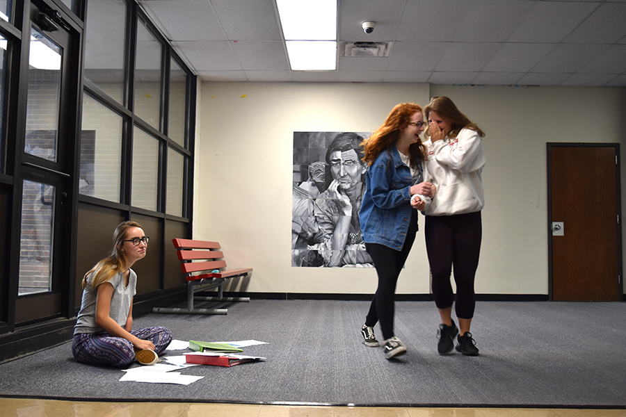 A freshman is bullied in the hallway, while peers laugh and watch but do nothing to help. 