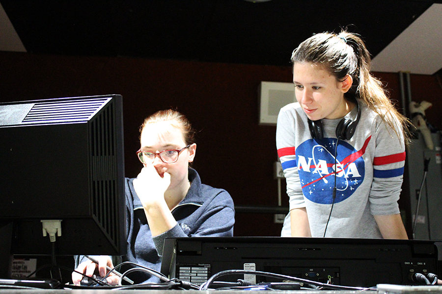 Juniors Kim Clyne and Sophie Spaulding check the light board, setting up for a dress rehearsal.