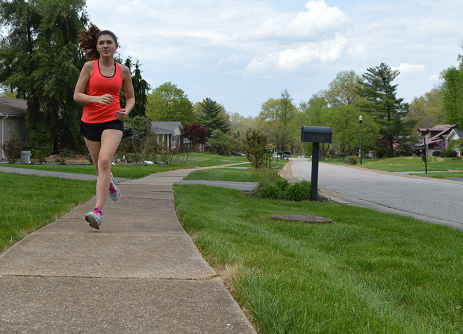 Running+down+the+street%2C+freshman+Emma+Caplinger+trains+for+upcoming+cross+country+summer+camps.