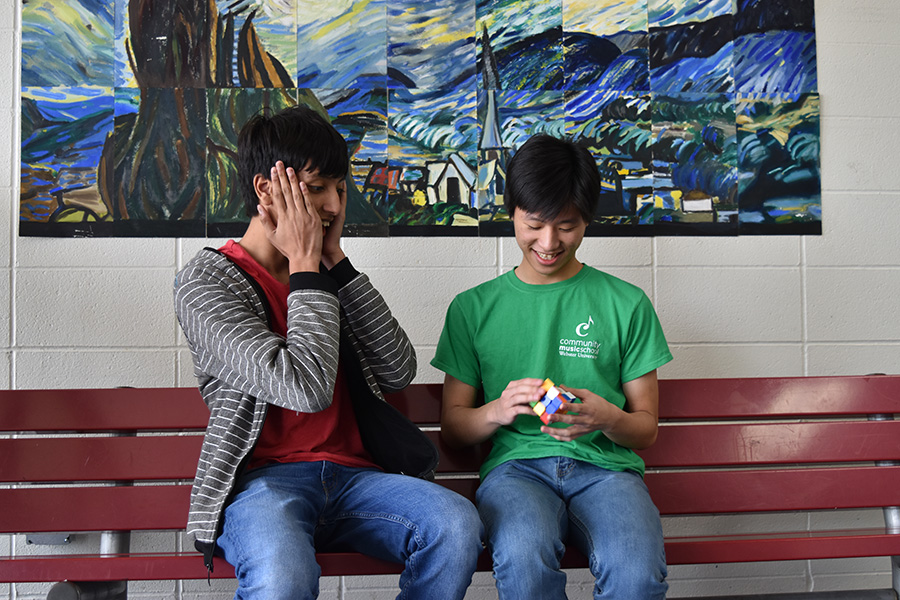 Shocked by the speed at which sophomore Jason Wan solves a Rubik’s cube, sophomore Neil Tomala watches him solve.