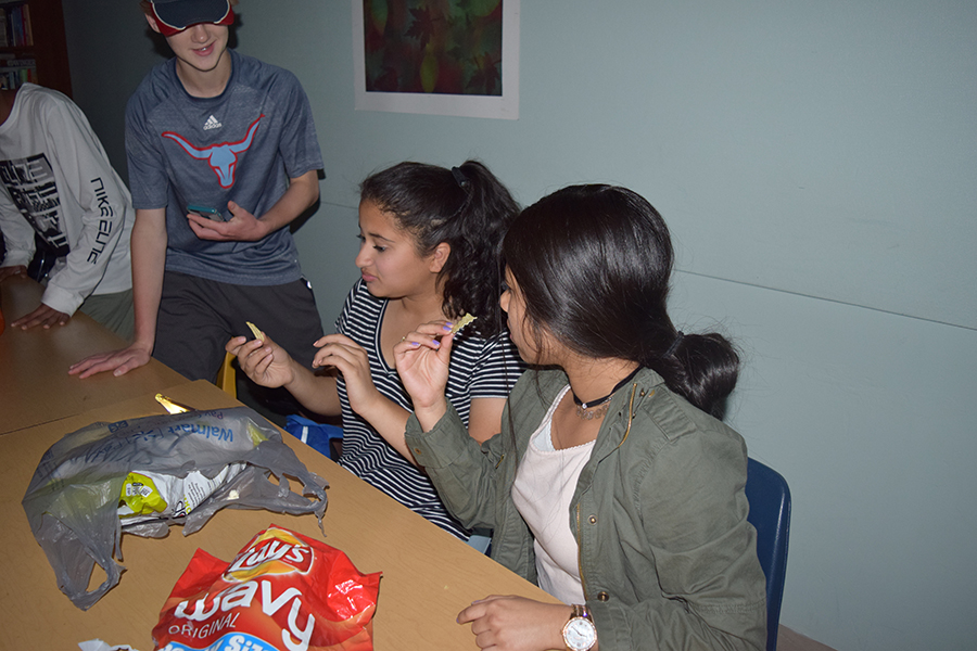 Freshmen Rabiah Hilaly and Umeera Farooq start a food party in class despite the power outage.