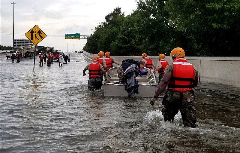 The Texas Army National Guard pulls a boat across a flooded highway in Houston.