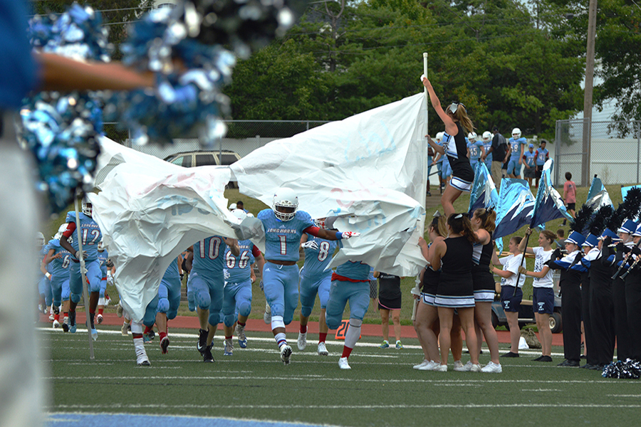 The varsity football team emerges through their sign prior to their first game of the season against Parkway South on Aug. 18. They went on to win the game 22-12.