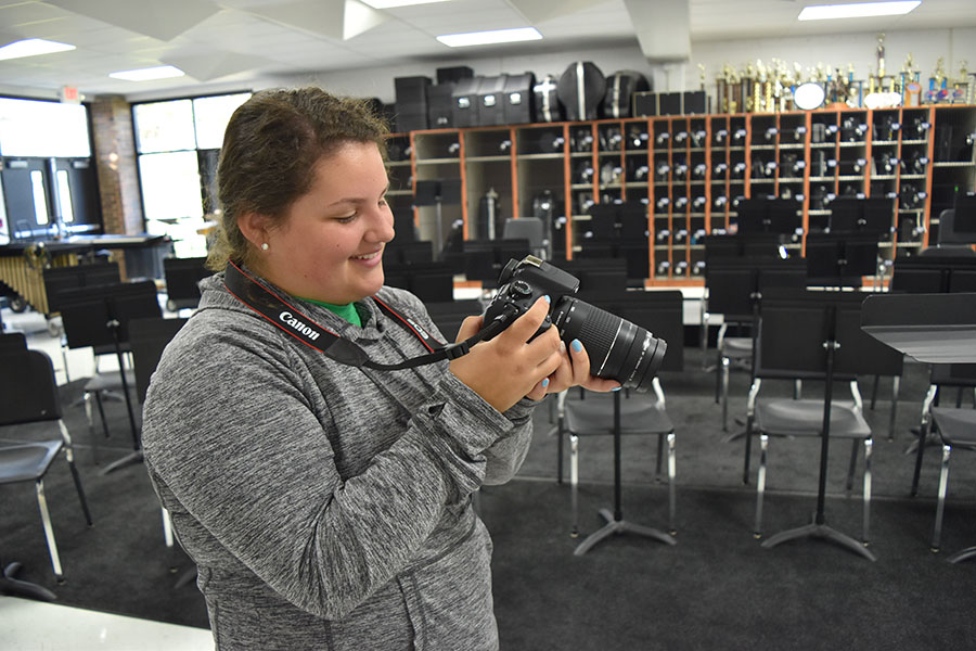 Back in the band room, Karl checks out some of the nearly 700 band photos she has taken during her time as manager.