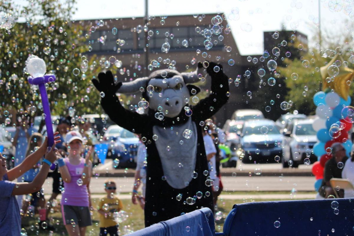 The school mascot poses in bubbles from a carnival bubble truck.