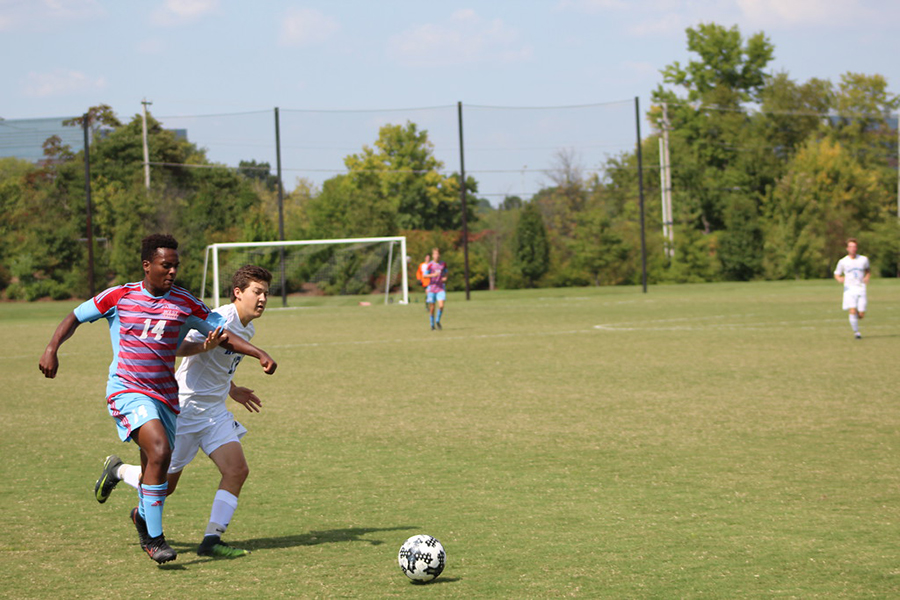 Rushing towards the ball, senior Leul Mesfin blocks a Westminster player from taking the ball. 