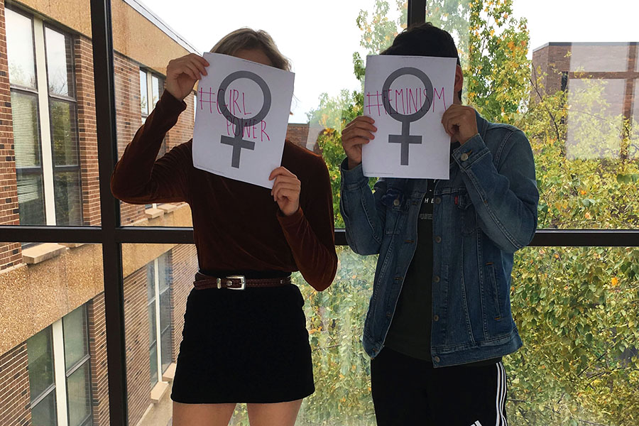 Students hold up feminist posters that say ‘#GIRLPOWER’ and ‘#FEMINISM’.