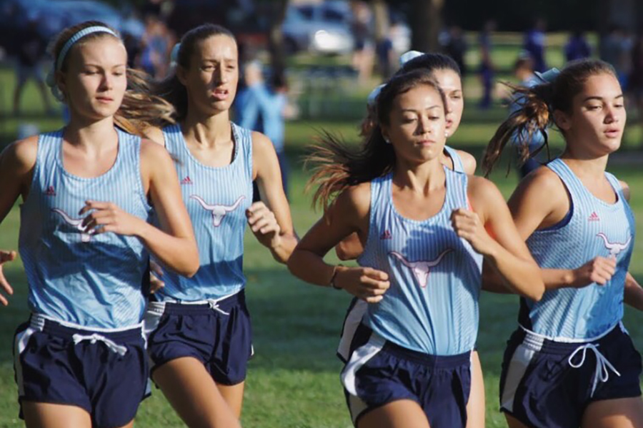 Girls varsity runners junior Claire Smout, senior Lauren Calvin, senior Emily Dickson and junior Chloe Hershenow run at the Aug.26 Parkway Quad.