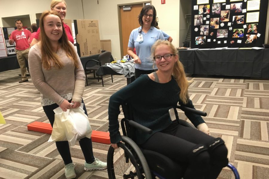 Perfecting their wheelchair skills, sophomores Maggie Lyerla and Valerie Reimer talk with physical therapists at Mercy Hospital. Each booth featured a different hands-on activity for students to get involved with. “My favorite part was learning how to do a wheelie in a wheelchair,” Lyerla said.