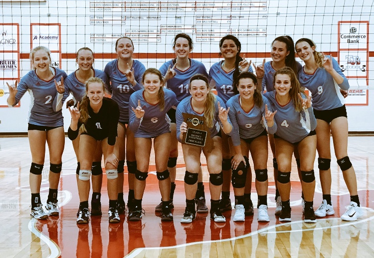 Posing+with+their+first+place+plaque%2C+the+varsity+girls+volleyball+team+make+longhorn+symbols+with+their+hands.+