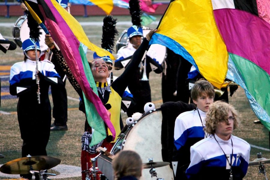 Senior Noelle McGuire waves her color guard flags in the air at the Jaguar Pride Marching invitational. The competition was the marching band’s last, and took place this Saturday. Color guard walked away having been awarded “Best Auxiliary,” which has not happened in a long time.