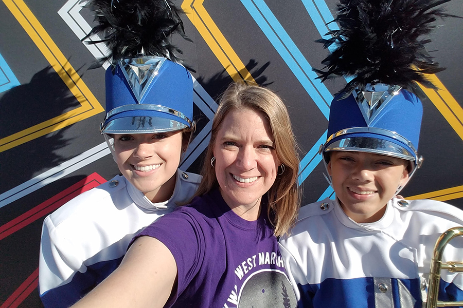 Foy (center) stands with her children Emily (left) and Charlie (right) at the Bands of America competition in 2016. “It’s so fun watching my kids participate in the band program like I did so many years ago,” Foy said.