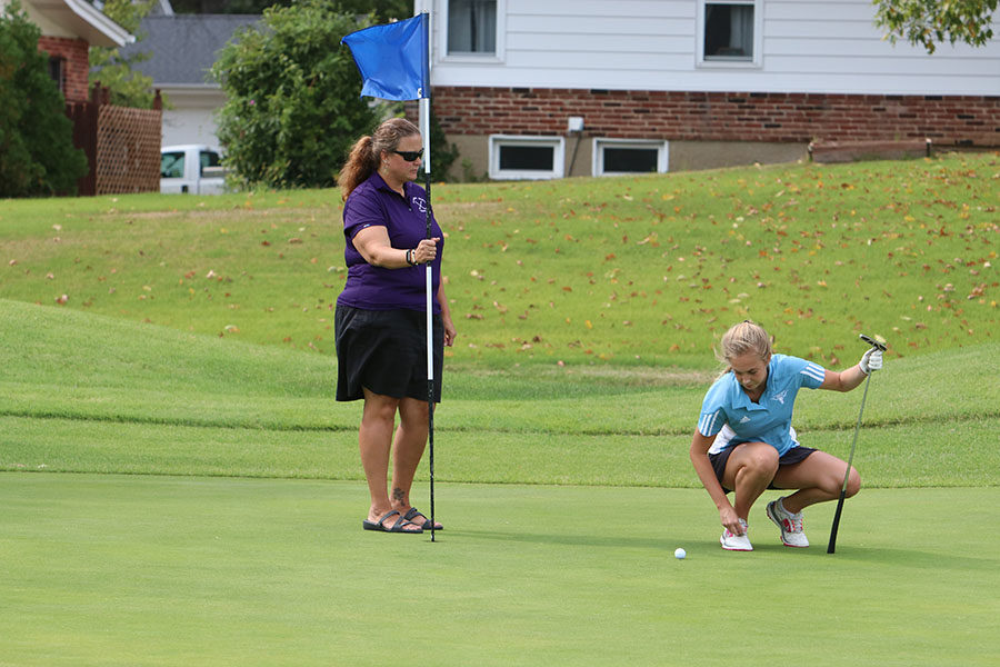 Lining up her putt, senior Kacie Bergh prepares a shot during a varsity match.