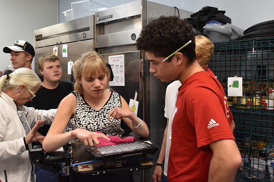 Standing up in her new chair, Kathryn collaborates with senior Junior Lopez during cooking mentor class, using her “talker.” Her new chair has made it easier for her to have conversations with her peers. “I’m learning to drive it by myself,” Kerckhoff said. 
