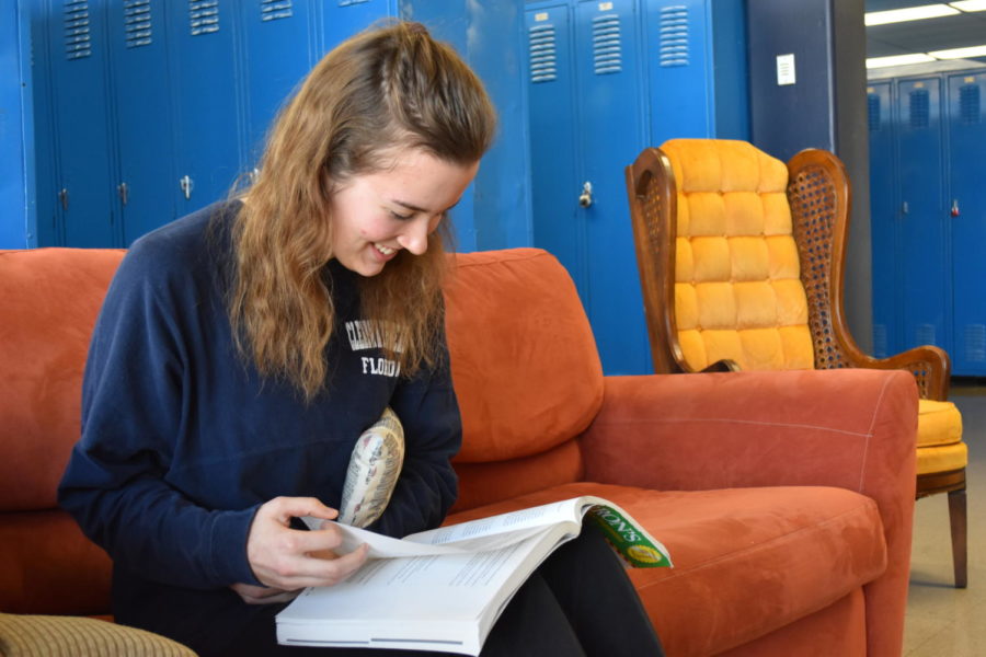 With plenty of makeup work to do after her week of recovery, Senior Kaleigh Stanfield looks through her AP Psychology review book and holds the pillow she was given by the hospital after surgery to her rib. “The pillow helps to compress the area where the rib was taken out,” Stanfield said.