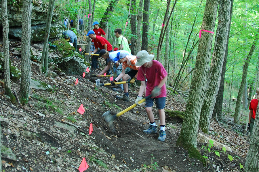 During a workday, Adam Johnson and Boy Scout Troop 631 help Gateway Off-Road Cyclists  on the Rock Hollow trail in Wildwood. Trail builders use a variety of tools, like the “pulaski” (axe-pick mix). 