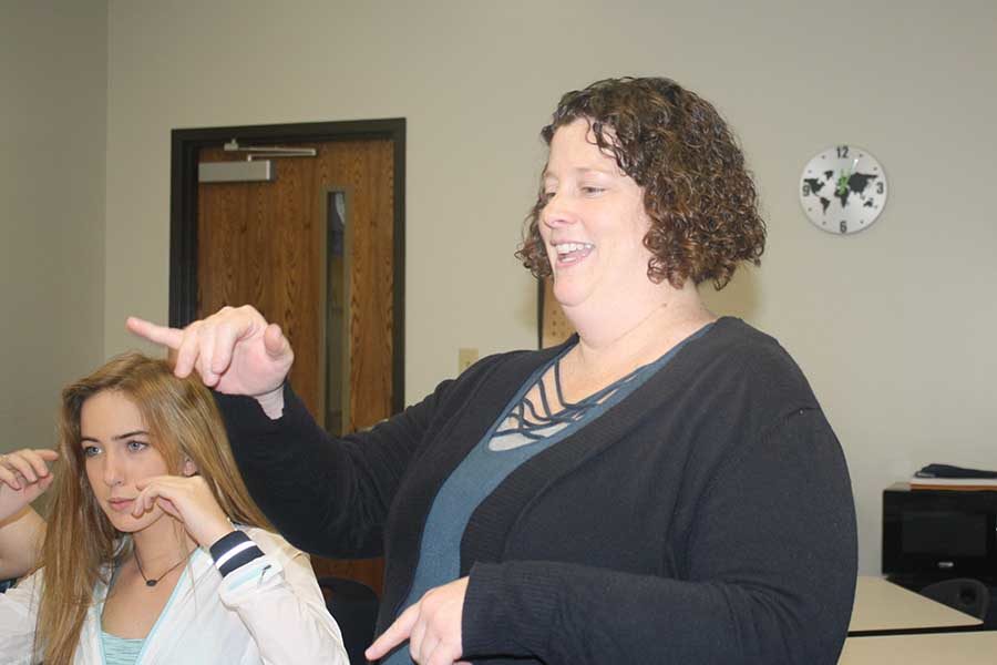 ASL teacher Tiffani Symons signs to one of her students in her American Sign Language II class. Symons has been teaching for 17 years. Students are only learning visually. I admire students who are up for this challenge, and my job as a teacher is to promote their learning and success, Symons said.