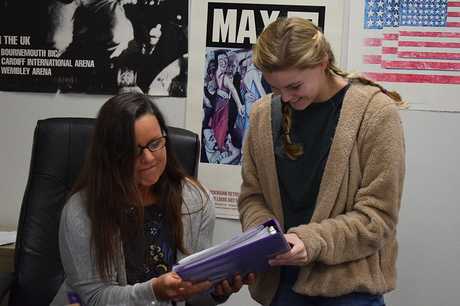 Helping sophomore Kelsey Long with an assignment, social studies teacher Kristen Collins reads Long’s response on a review packet. Long enrolled in World History because it was a very engaging class. “Collins was one of the best teachers I’ve ever had, because she helped organize us and she worked overtime to be sure we were successful,” Long said.  