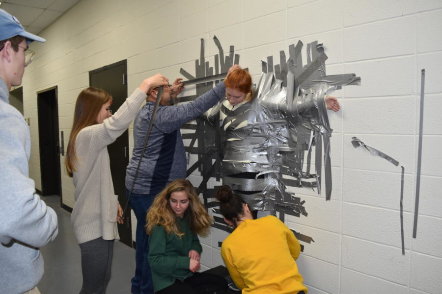 In eight minutes, the Pathfinder editorial board and building manager Scott Bollmann duct taped arts and entertainment editor junior Nell Jaskowiak to the wall for a test run of the “Duct Tape Your Teacher to the Wall” fundraiser that will be next Friday, Jan. 26. The money raised from this fundraiser will go to their trip to New York to accept the Columbia Scholastic Press Association Crown Award, which is one of the highest awards in high school journalism. “It was pretty cool to know that basically just [the duct tape] on my arms and legs was holding me to a wall in the school basement,” Jaskowiak said. “We’ve made a thriving website and got Best of Sno last year and hopefully this year again. Now were one of the top 19 schools in the nation, which is insane, so we’d like to be able to go receive [the Crown Award].”
