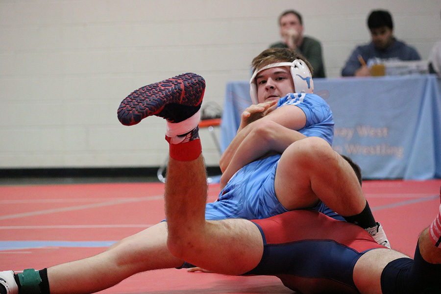 Senior Jacob Brauner attempts to pin his opponent from Parkway South. In the end, Parkway South junior Connor Hale defeated Brauner in 2:29. “Even though I lost that round, the team still cheered me on as if I had won,” Brauner said. 

