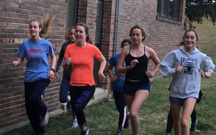 Running their warm-up lap, sophomore Laura Rein, senior Jane Fuller, junior Natalie Butler and junior Chloe Hershenow get ready to hit the roads. After warm-up girls split into groups and completed their workout. “Winter running helps motivate me to run on the coldest days because I know I will have these girls by my side to do it with,” Hershenow said. 
