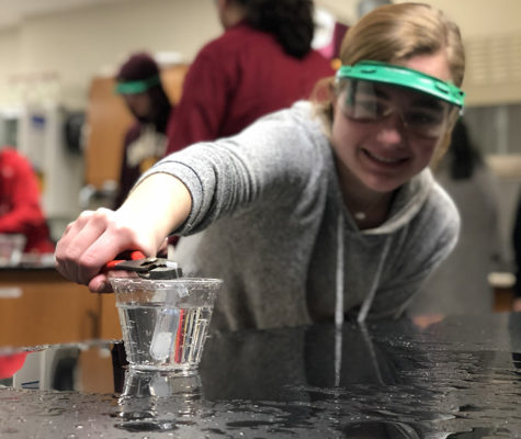 Squeezing a pipette of dry ice, junior Caroline Williams waits for the cup of water to explode. Students in chemistry conducted the lab to observe the phase changes of dry ice (Carbon Dioxide). “It was kind of scary because I didn’t know when it was gonna blow up on me, but then the molecules started spinning and the water shot up everywhere -- it’s like the highlight of chemistry,” Williams said. 