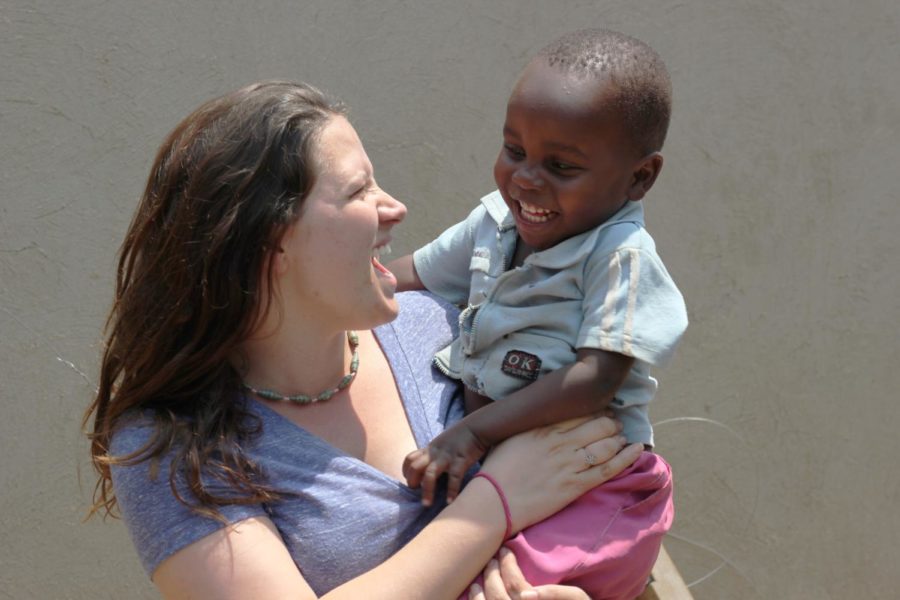 Rebecca Lintner poses with her two-year-old friend Mark, also called Markaroni, who is the son of a single mother who started the first women’s empowerment group for HIV positive women.