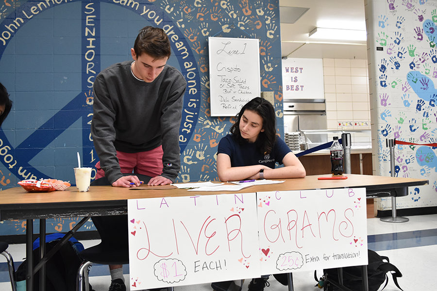 Juniors Mitchell Norman and Natan Shrpingman sell livergrams during second lunch. The paper livers are sold for $1, and feature Latin phrases related to the holiday. “In ancient Rome they thought love came from the liver, and so we’re playing off that instead of a traditional heart,” Shrpingman said.