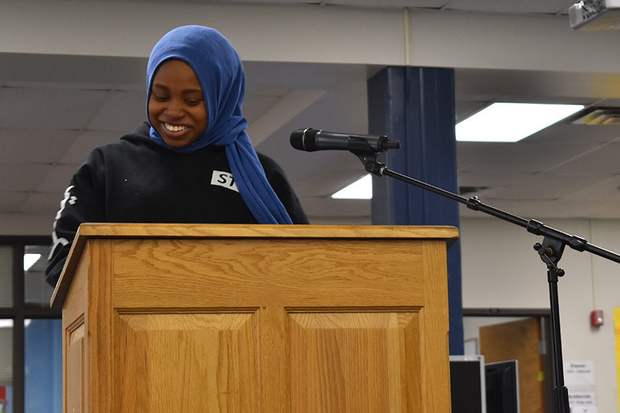 Junior Maryam Oyebamiji laughs during her reading. Oyebamiji had been an audience member of the read-in for the last two years, but spontaneously chose to read this year. “Mr. Welch kept egging me to go, he kept staring at me, and I was like, ‘You know, why not,’ and I already had a book in my hands so I went up,” Oyebamiji said.