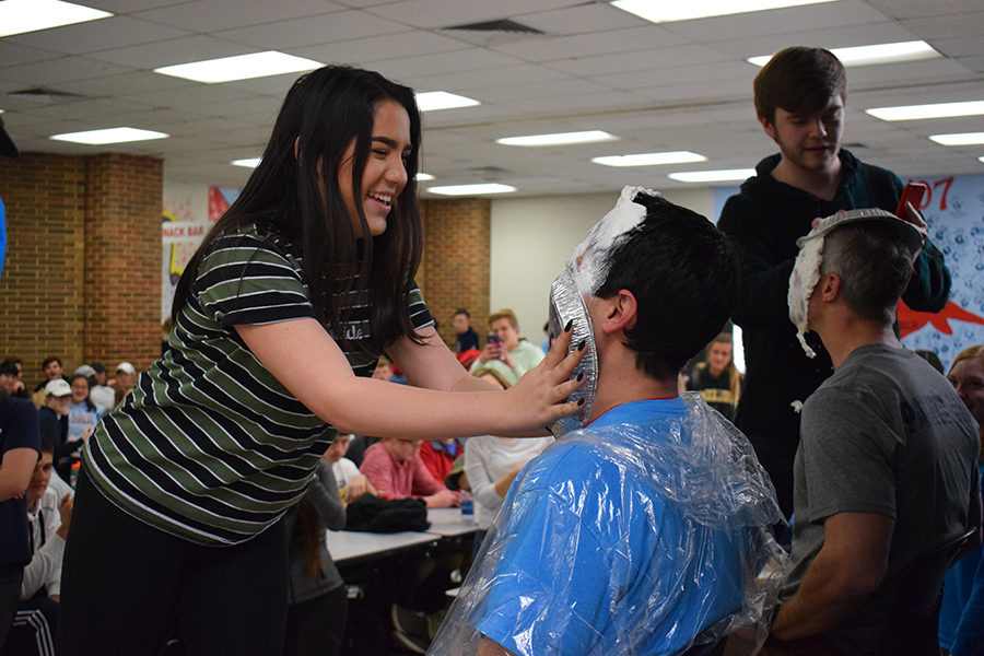 Smashing a pie into Assistant Principal Mario Pupillos face, sophomore Hillary Herrera celebrates Pie Day with her classmates. Each year Key Club holds a Cash for Cancer fundraiser for Friends of Kids With Cancer. “When they called my name to pie Mr. Pupillo in the face my heart stopped,” Herrera said. “All my friends were cheering for me, and he gave me a high-five afterwards. It’s such a crazy and bizarre thing to do, so I’m really happy I got to pie my principal in the face.”