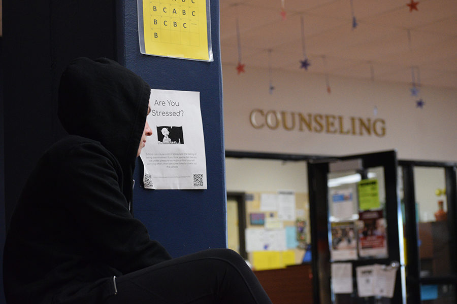 A student sits outside of the counseling office, looking at a poster directed at stressed students. The posters were hung in response to the rising anxiety levels of students. Because of busy schedules, counselors have limited time to deal with the emotional needs of students, and so students are forced to look elsewhere for help.