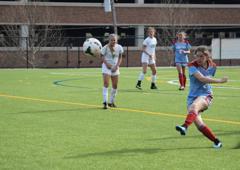 Junior Kaleigh Kastberg swings into a free kick, turf flying into the air. The varsity girls competed against Nerinx Hall on April 13. "We ended up losing 2-0. We were trying to get a goal back in the last ten minutes, so we gave up a second goal," Kasper said. "It went well though; I play defense, and so we were trying to shut down as many forwards as possible."
