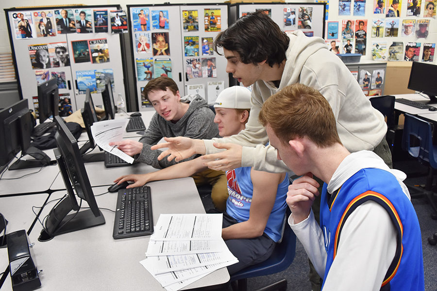 Seniors James Banks, Jackson Piles, Lorenzo Giganti and Jack Cromley look through Blue Brew applications. 