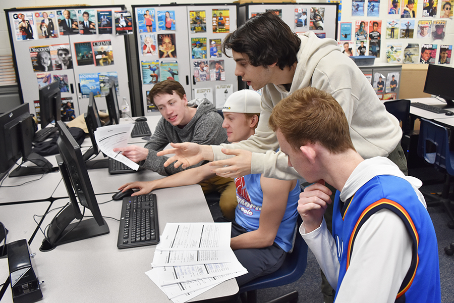 Seniors James Banks, Jackson Piles, Lorenzo Giganti and Jack Cromley look through Blue Brew applications.