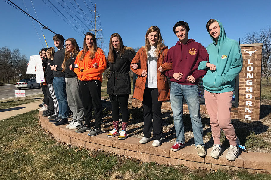 Students stand along Clayton road as a part of the nationwide walkout on March 14. Teachers threatened students walking out of the school with detention, but 14 students went anyway instead of attending the protest in the gym. “It felt good, to stand out there in solidarity with other students across the nation,” junior Harper Stewart said. “We linked arms, and as cars passed by they honked at us and drivers encouraged us. It was an incredibly powerful experience.”