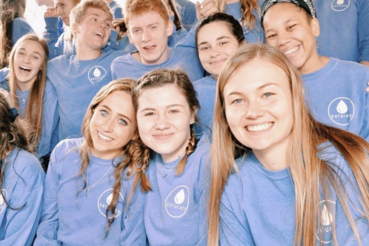 Surrounded by fellow BreakDown members, junior Claire Smout poses with her peers after a winter retreat for BreakDown leaders. “Coming back to the school and hearing about how things are improving for students is one of the most rewarding parts of being apart of BreakDown,” Smout said.  