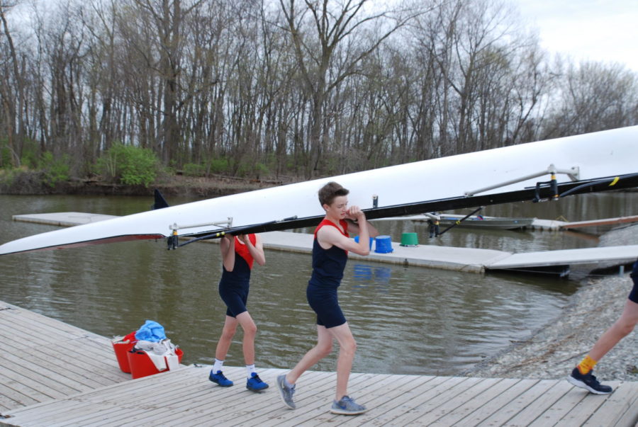 After finishing his race, freshman Jonah Gaskill carries the boat on his shoulders towards the boathouse. Gaskill raced in two races placing third in both. “It’s really fun to be on the team,” Gaskill said. “Everyone is really nice and positive. It’s a good environment and everyone is always tries hard to improve.”  
